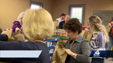 Volunteers pack brown bags with food for veterans